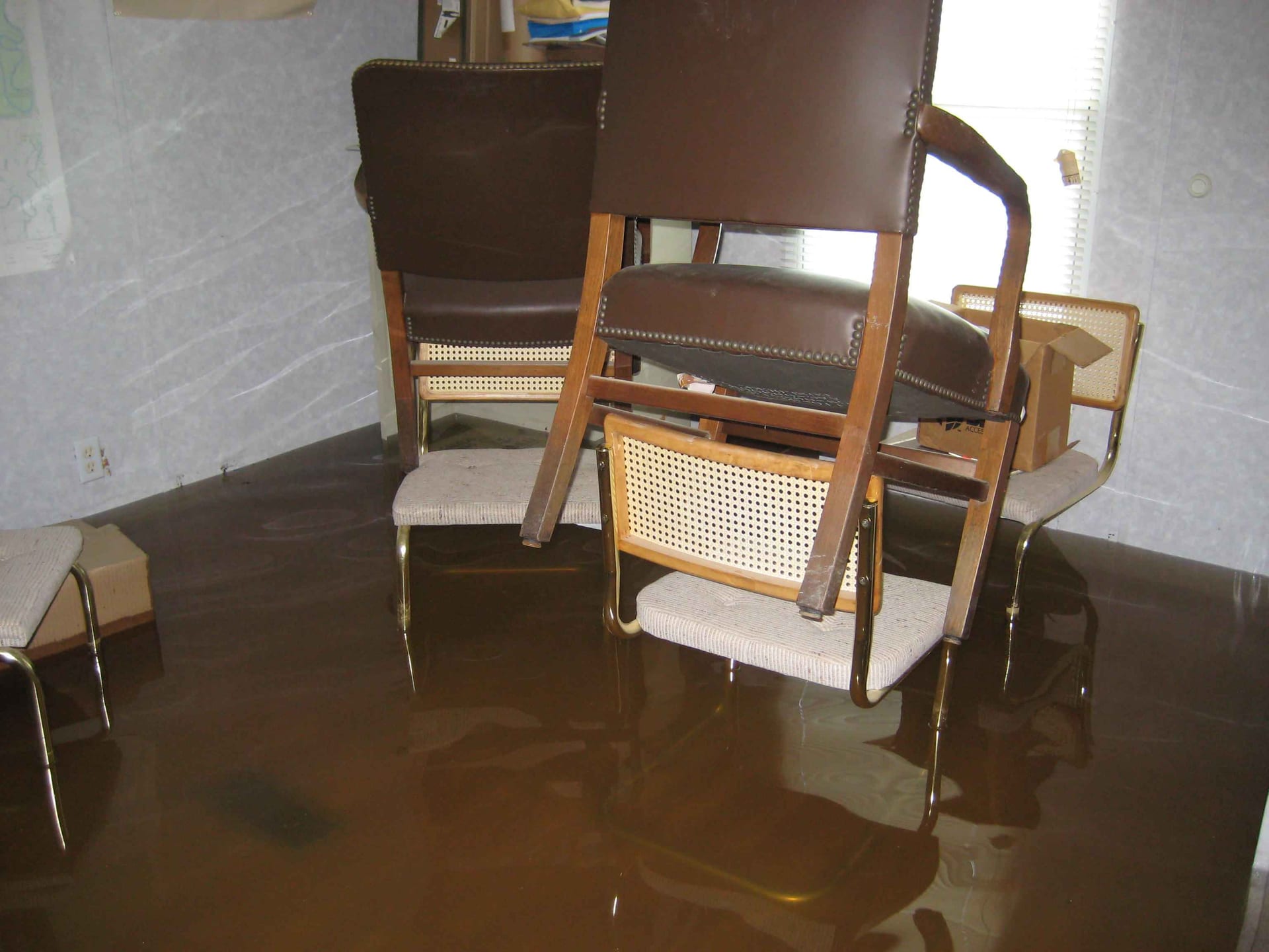 Floodwater across the floor of a furnished room